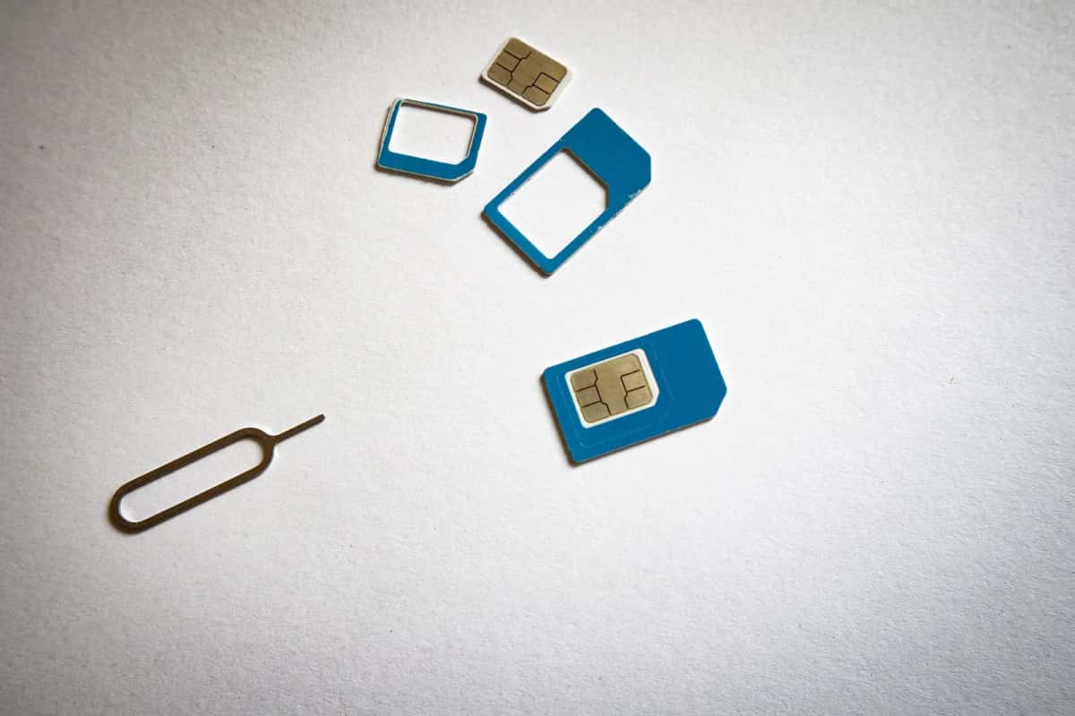 Cartes SIM de différents formats et outil d'éjection posés sur un fond blanc
