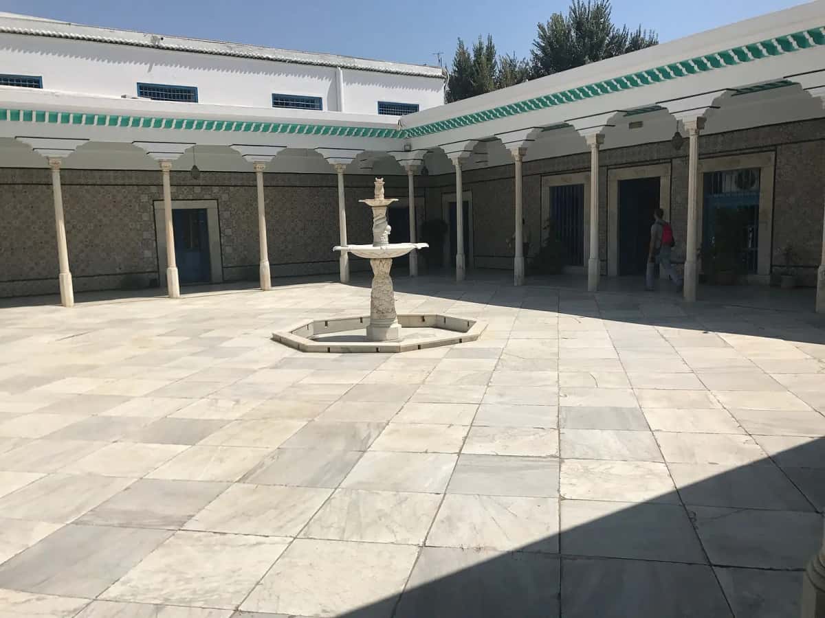 Cour intérieure à arcades avec une fontaine dans une demeure tunisienne