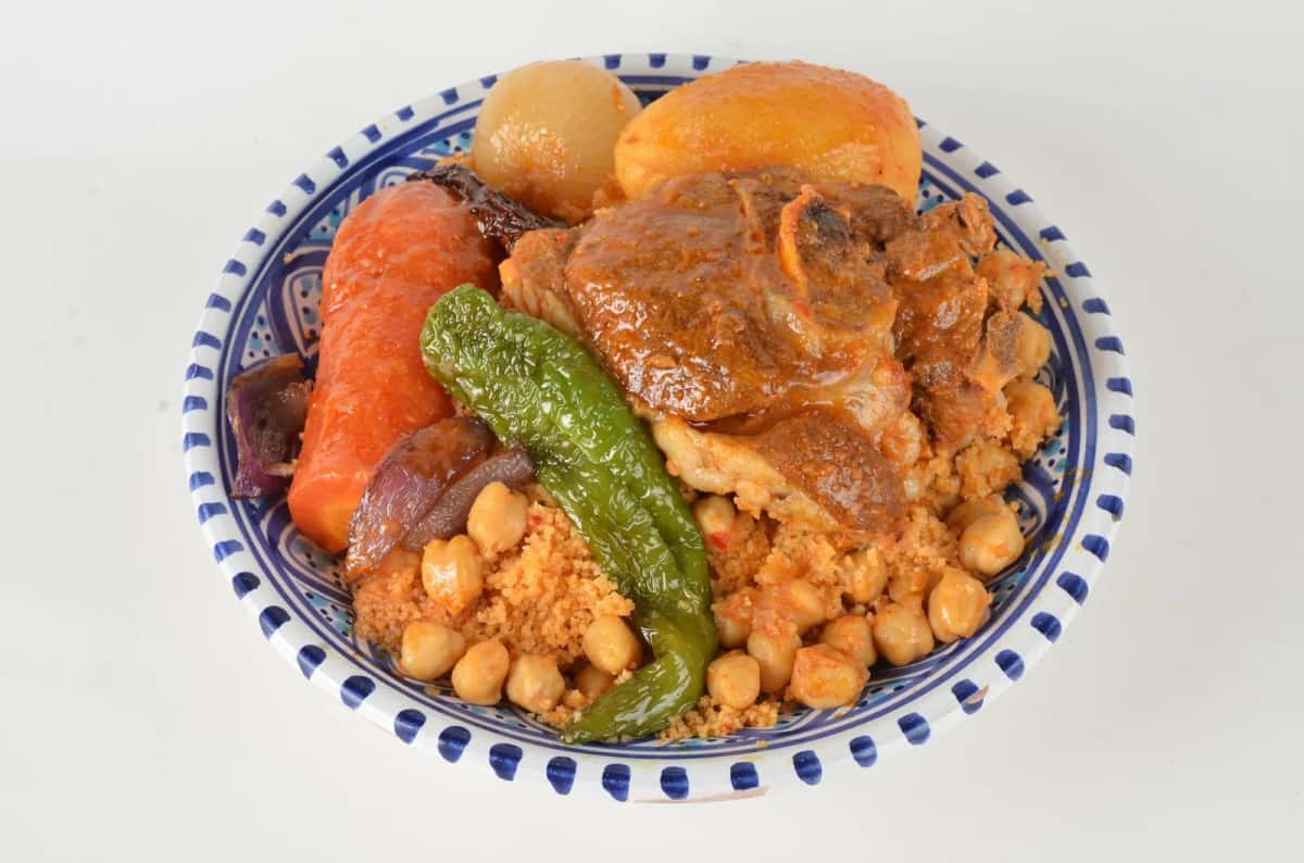 Couscous tunisien à l'agneau, légumes et pois chiches dans un plat bleu