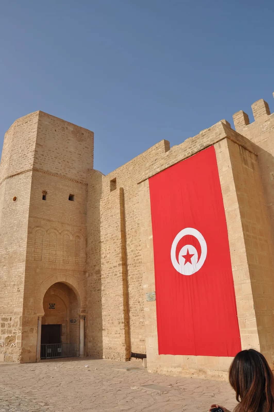 Grand drapeau tunisien déployé sur le mur d'un ribat