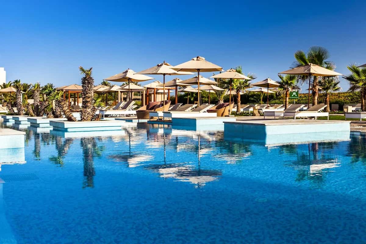 Piscine bleue, parasols et transats du TUI Blue Palm Beach Palace à Mezraia, hôtel réservé aux adultes