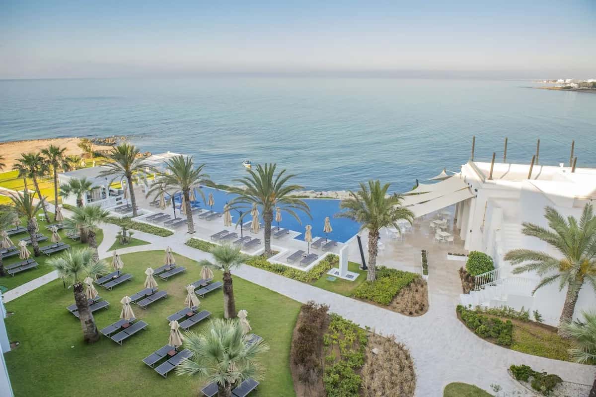 Piscine à débordement, transats et jardin face à la mer à La Badira, hôtel réservé aux adultes à Hammamet