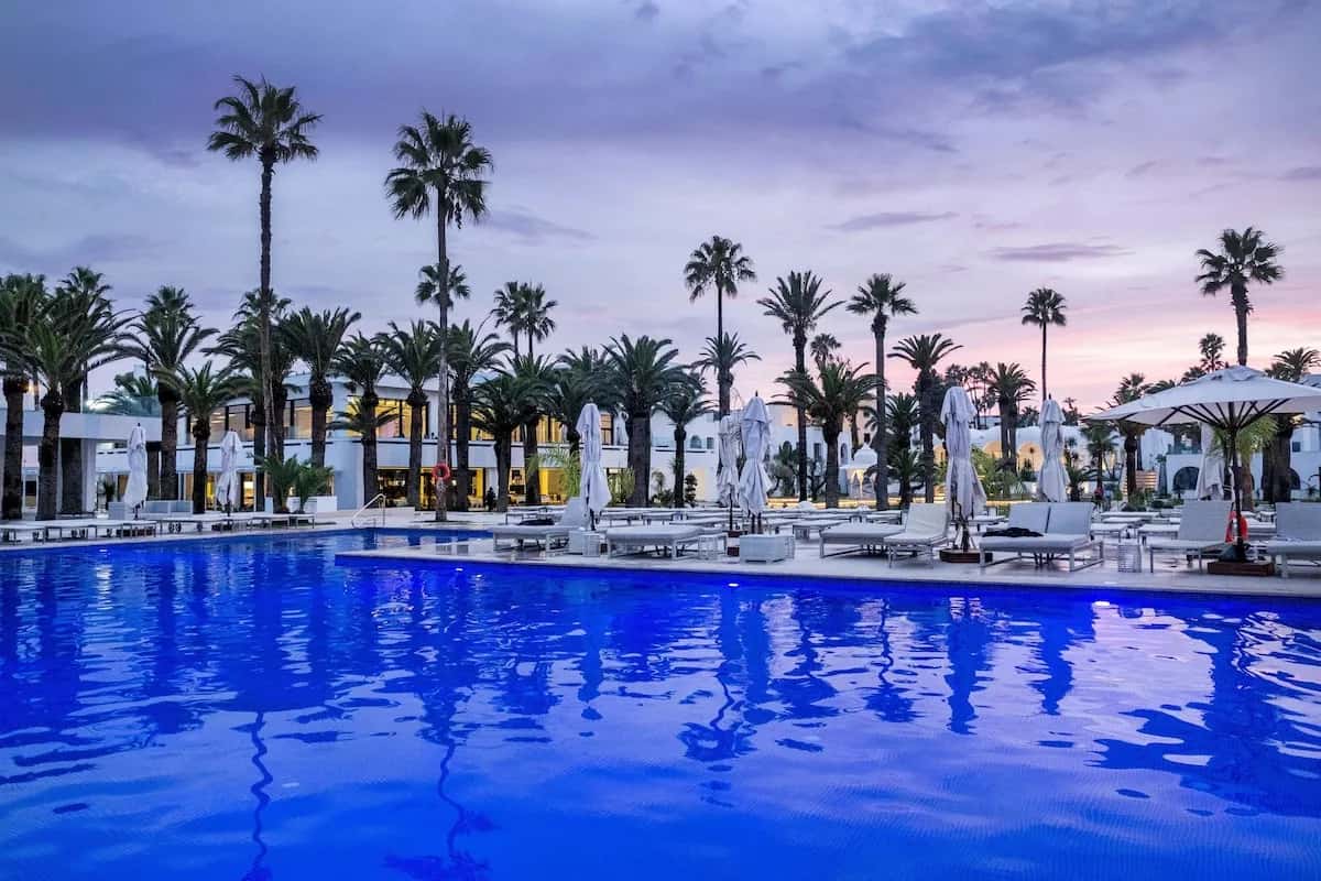 Grande piscine et transats au crépuscule à Les Orangers Garden Villas & Bungalows, Hammamet