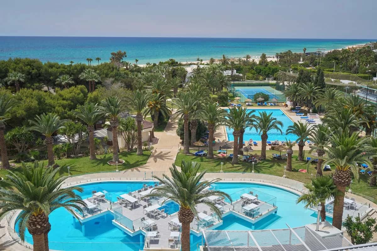 Vue aérienne des piscines et des palmiers avec la mer en fond au Magic Hotel Manar (TUI Blue Manar), Hammamet