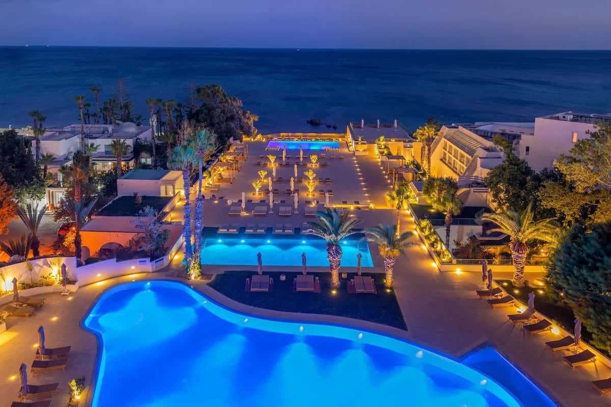 Piscines éclairées et terrasses face à la mer du Royal Azur Thalassa à Hammamet, vue aérienne au crépuscule