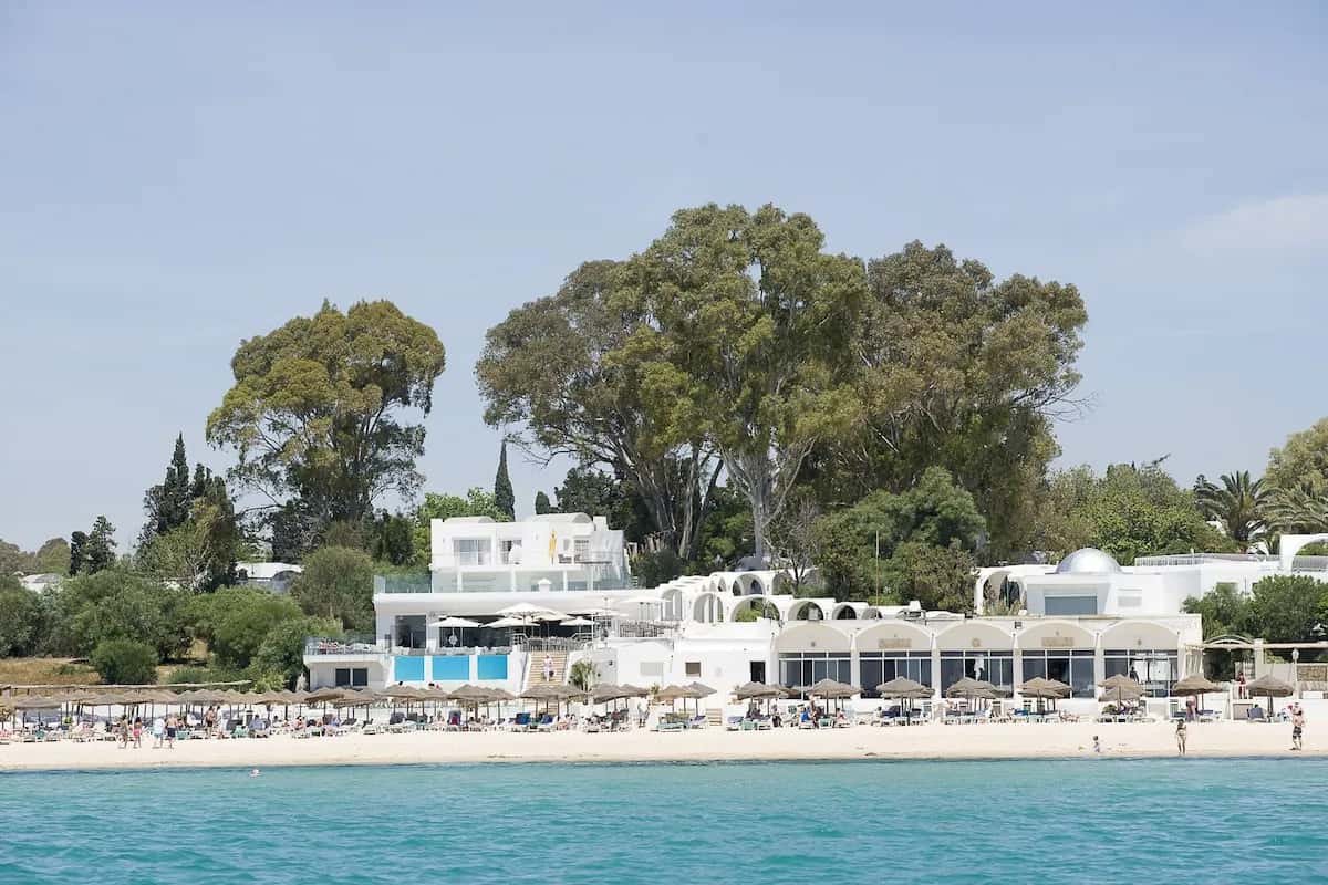 The Sindbad à Hammamet : bâtiments blancs au bord de la plage de sable, vue depuis la mer