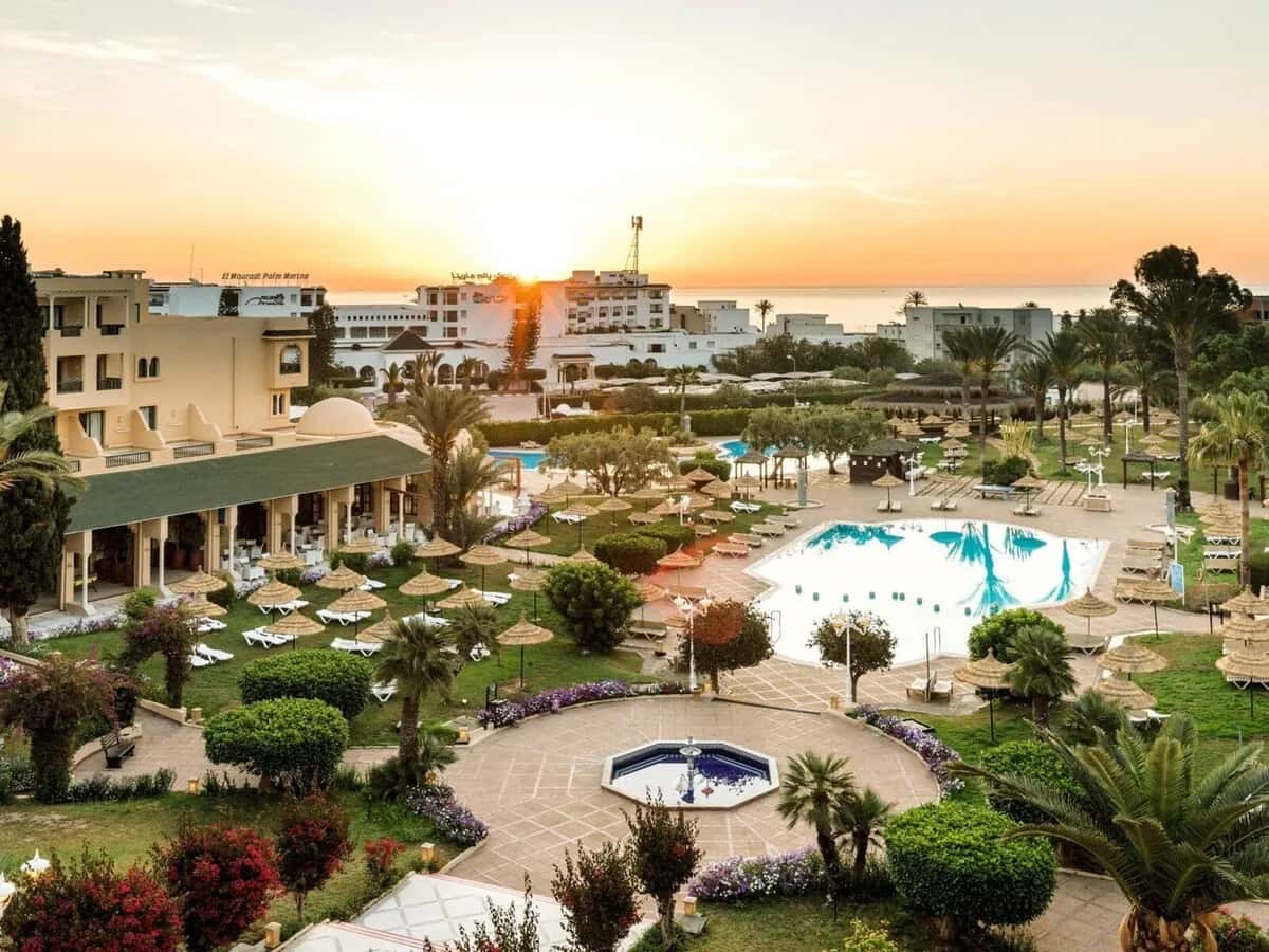 Jardin, bâtiments et piscine du Royal Kenz Thalasso & Spa à Port El Kantaoui au soleil couchant