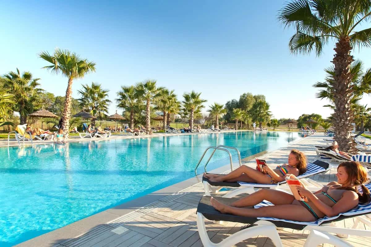 Piscine bordée de palmiers et de transats au Seabel Alhambra Beach Golf & Spa, Port El Kantaoui