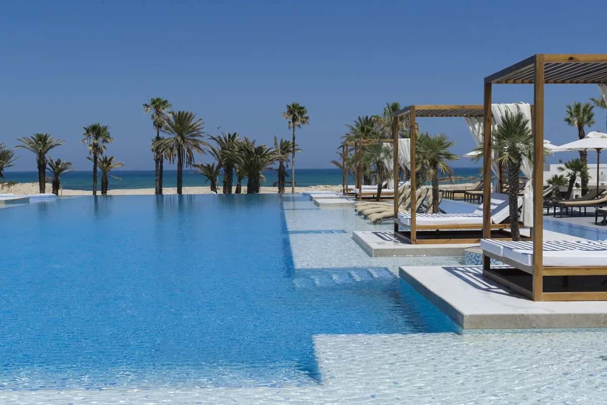 Grande piscine à débordement avec lits balinais face à la mer à l'hôtel Tour Khalef Marhaba Thalasso & Spa à Sousse