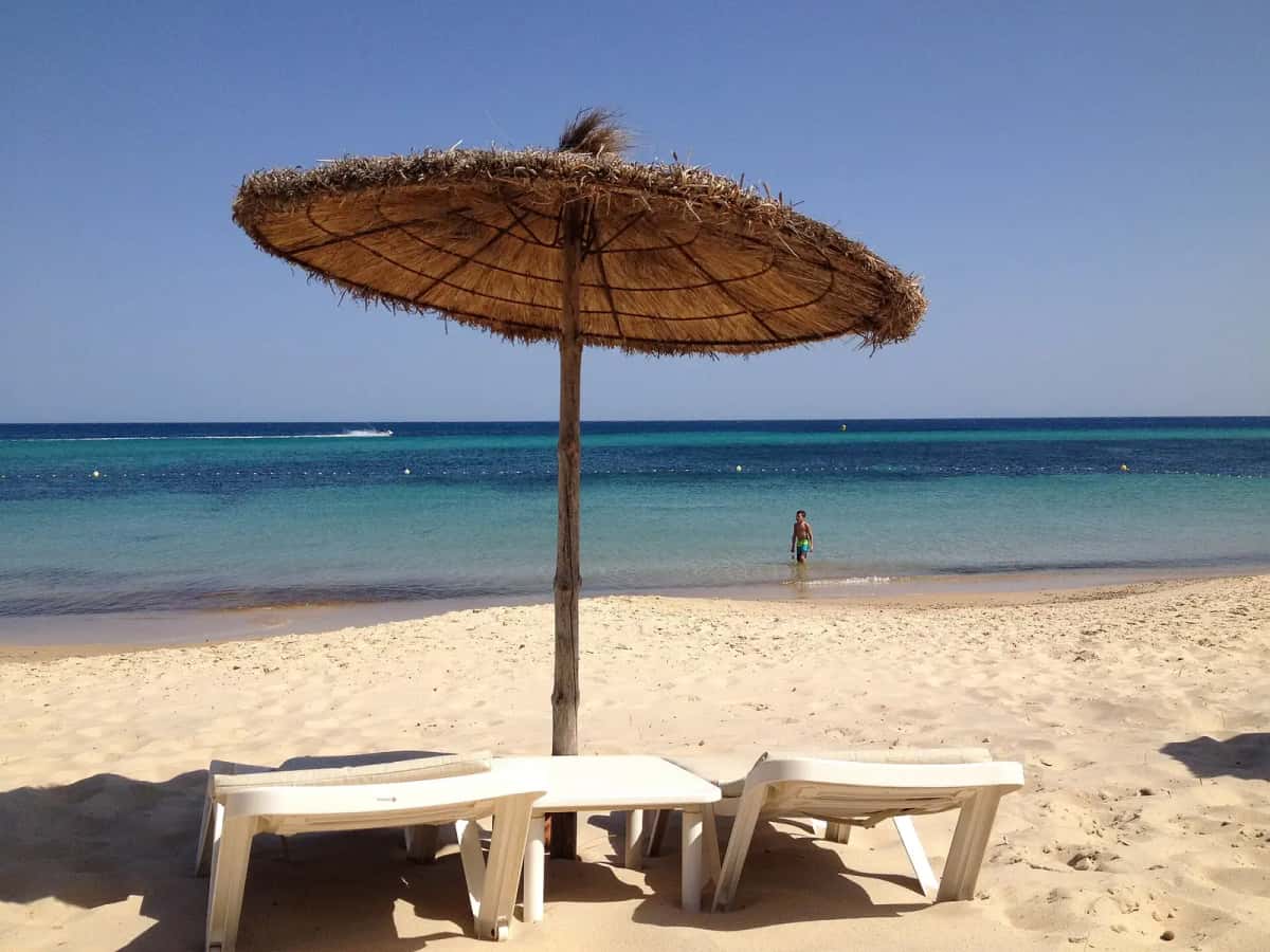 Parasol de paille et mer turquoise sur une plage de Hammamet