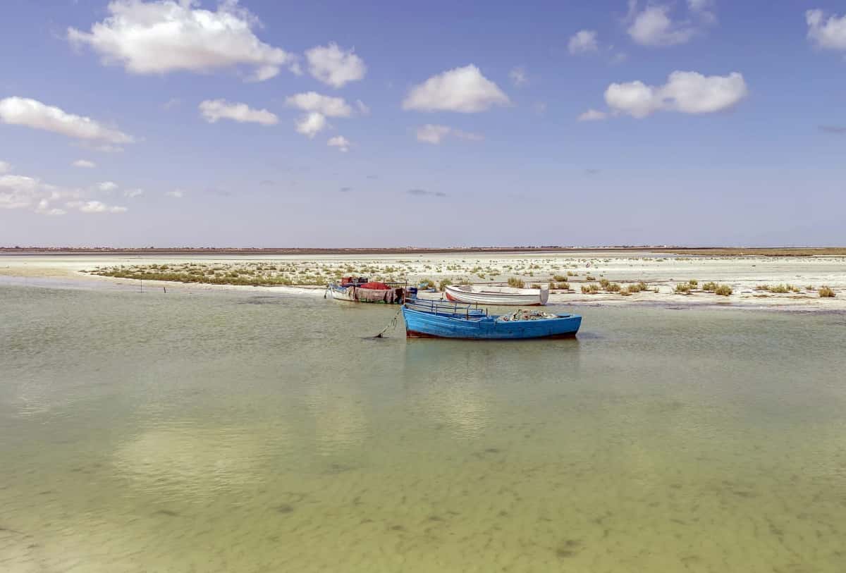 Barques de pêche dans les eaux peu profondes de la plage de Hassi Jerbi, à Zarzis