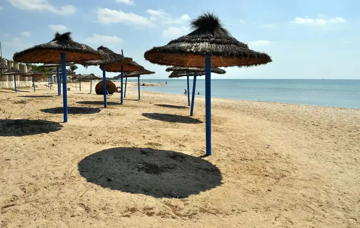 Parasols de paille sur la plage de sable de Nabeul, au Cap Bon