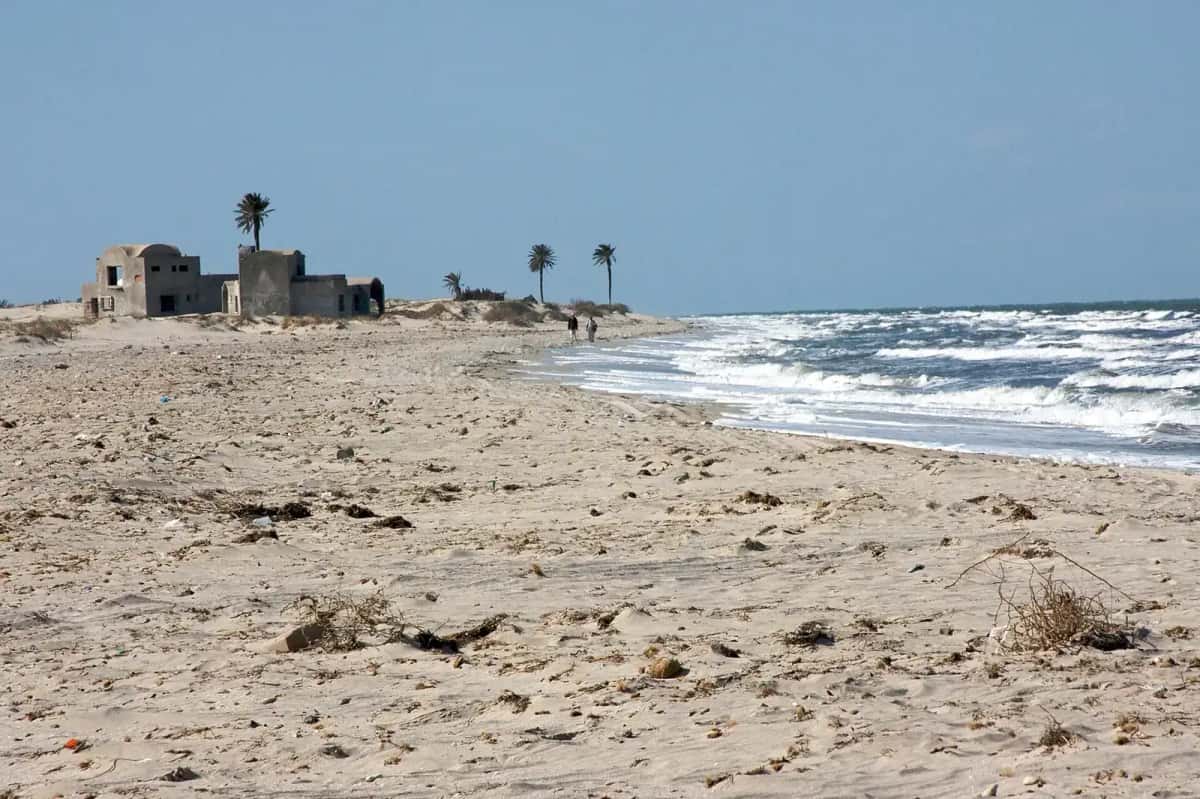 Plage non aménagée du littoral de Djerba, sable clair et bâtiment en ruine, sud tunisien