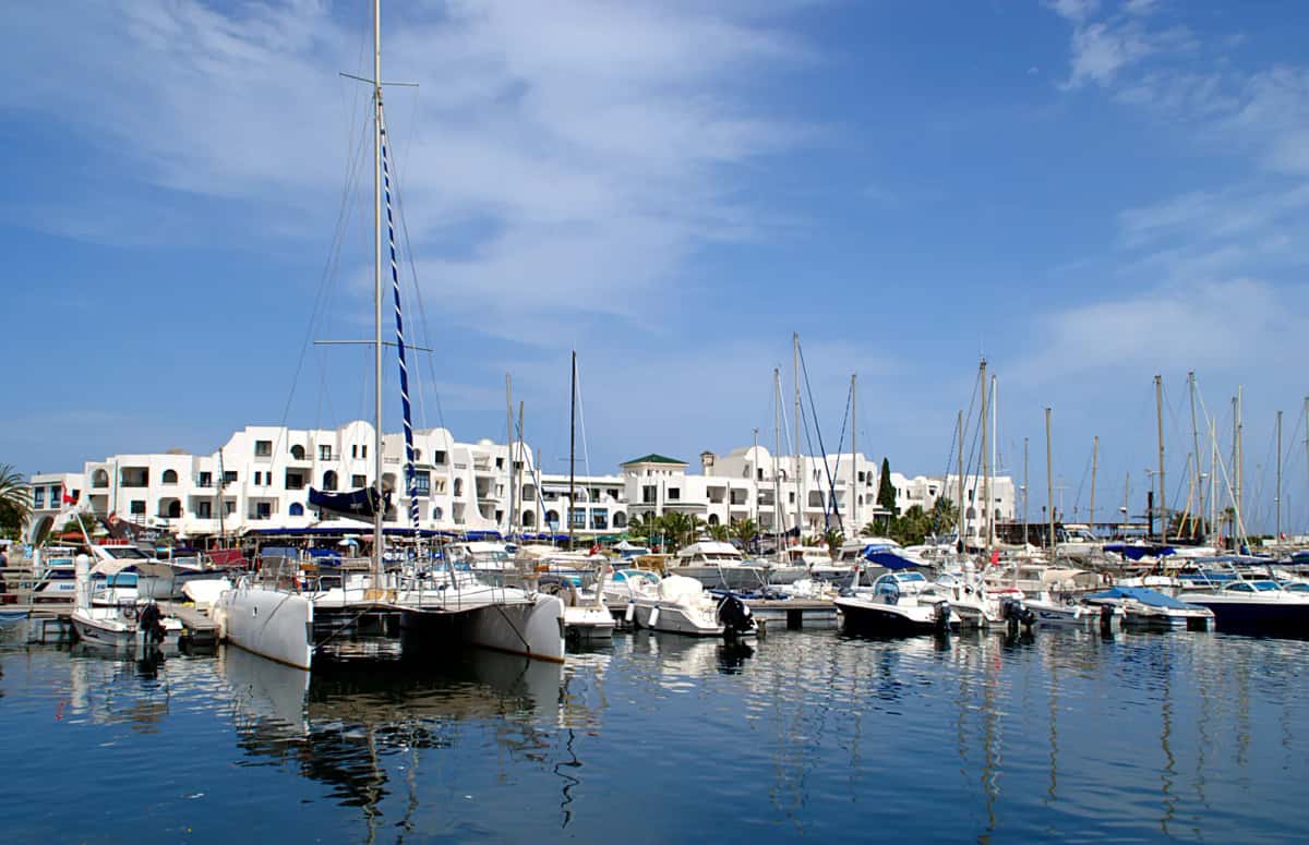 Marina de Port El Kantaoui près de Sousse : voiliers et catamaran amarrés devant les bâtiments blancs de la station
