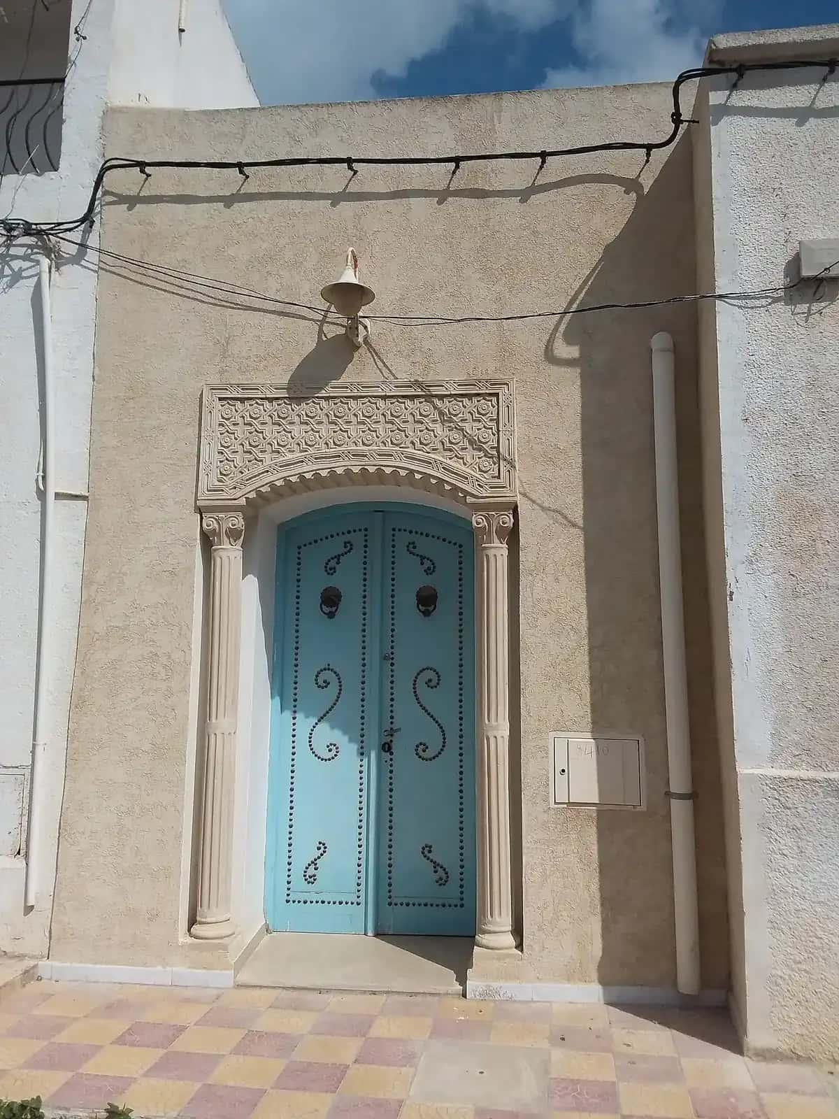 Porte bleue traditionnelle encadrée de pierre, à Kelibia