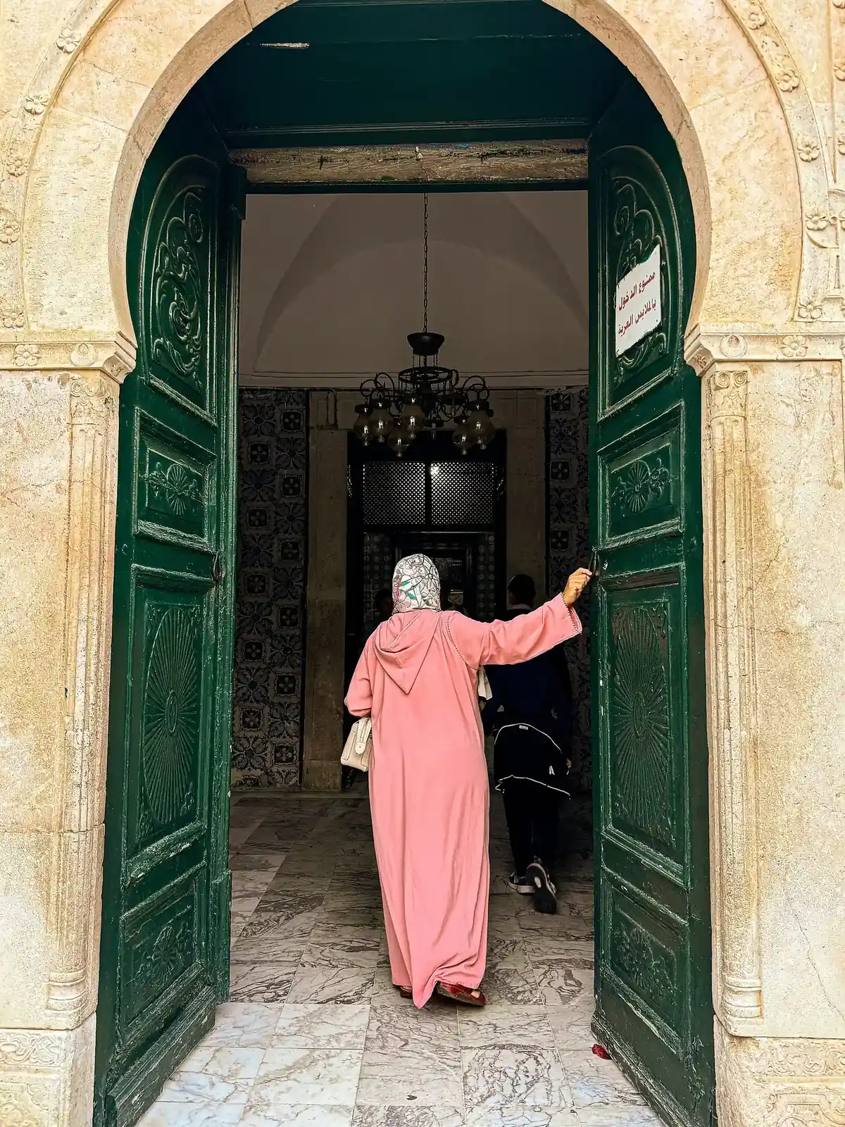 Porte verte et mur blanc dans une ruelle de la médina de Tunis