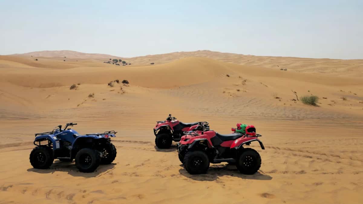 Trois quads garés dans les dunes de sable