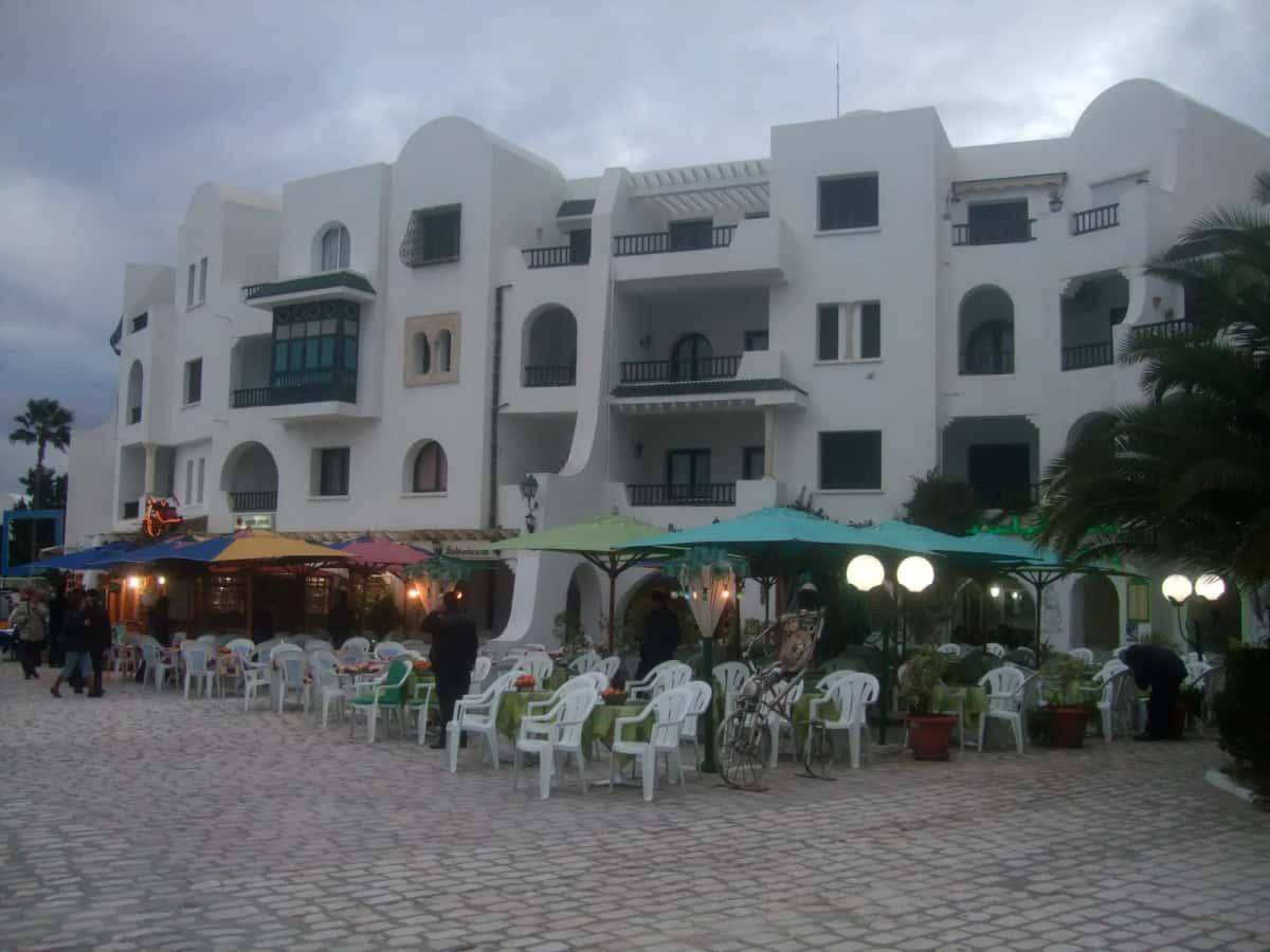 Terrasses de restaurants sous les parasols, sur les quais pavés de Port El Kantaoui, au crépuscule