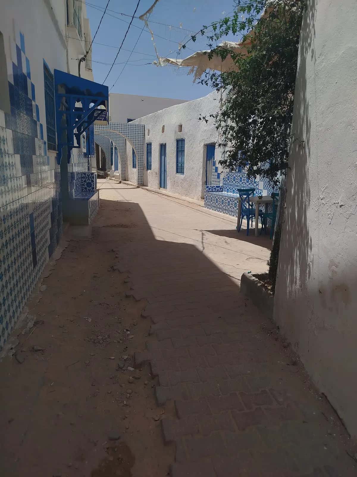 Ruelle blanche aux menuiseries bleues dans un village de Djerba