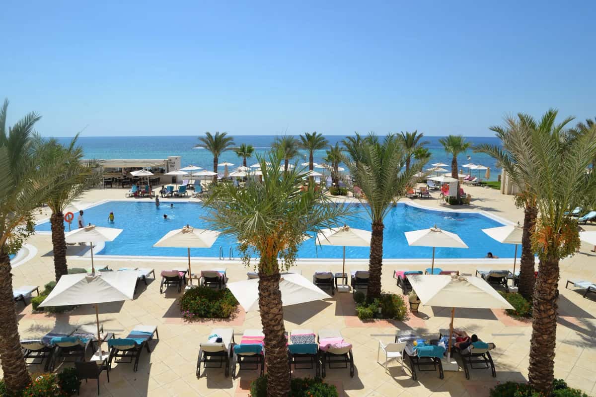 Piscine bordée de palmiers face à la mer à l'hôtel Radisson Blu Resort & Thalasso, Hammamet