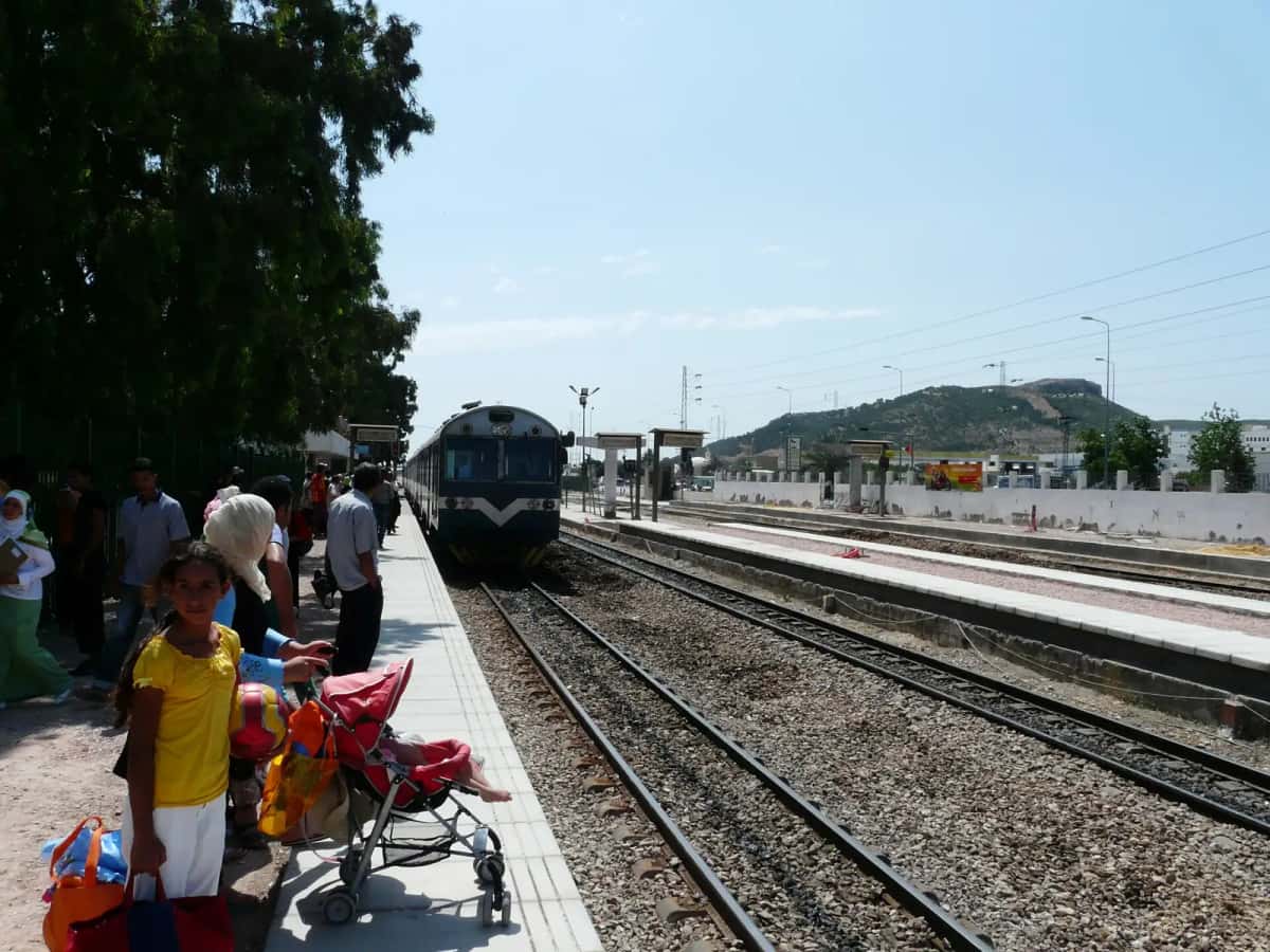 Train à quai et voyageurs dans une gare tunisienne